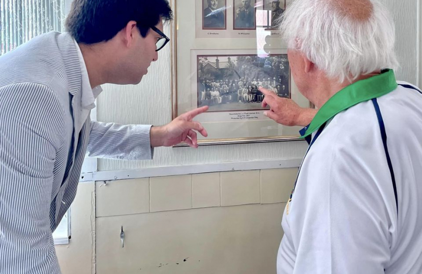 Ranil and a member looking at one of the oldest photos of the club